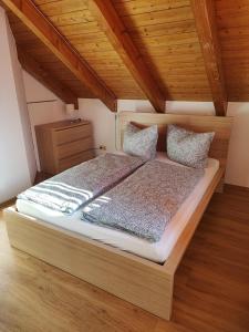 uma cama grande num quarto com tecto em madeira em FeWo am Park- mit Ausblick auf den Europa-Park em Rust