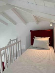 a white bed with a red headboard in a room at Syboro in Aloïziánika