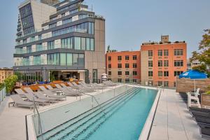 uma piscina com espreguiçadeiras e um edifício em Hotel Indigo - Williamsburg - Brooklyn, an IHG Hotel em Brooklyn