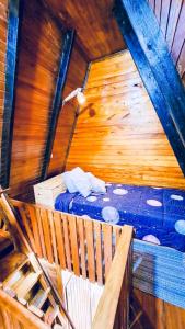 een kamer met een bed in een houten hut bij Shizen hospedaje, eventos y camping 