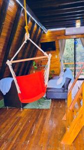 eine rote Hängematte in einem Zimmer mit einem Bett in der Unterkunft Shizen hospedaje, eventos y camping 