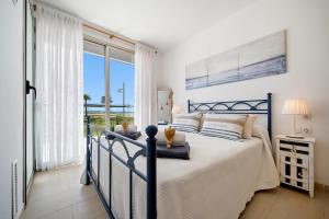 a bedroom with a bed with a view of the ocean at 1ª LÍNEA DE PLAYA. Apartamento: LA CALMA in Comarruga