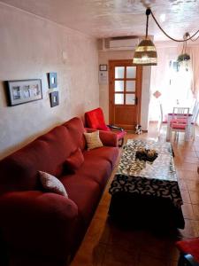 a living room with a red couch and a table at Entre Vistas in Zahara de la Sierra