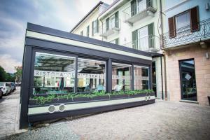 un front de magasin avec une fenêtre comportant des plantes dans l'établissement Hotel Ponti, à Angera