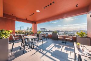 un patio con tavoli e sedie sul tetto di Breakfast Included at Regatta Living 605 a Los Prados