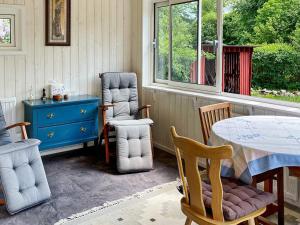 a dining room with a table and chairs and a blue dresser at Holiday home Huaröd in Huaröd