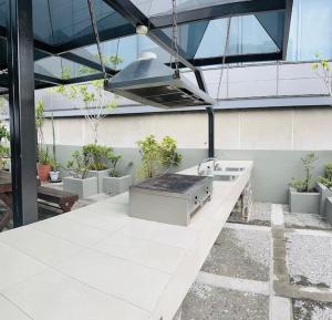 eine Außenküche mit einer Spüle und Topfpflanzen in der Unterkunft GREAT COZY LOFT LUXORY POOL/ GYM/JACUZZI/ROOF TOP in Mexiko-Stadt