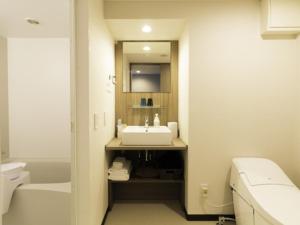 y baño con lavabo, aseo y espejo. en La'gent Stay Hakodate Ekimae - Vacation STAY 75062v, en Hakodate