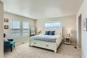 a bedroom with a white bed and a window at Brand New Townhome with King Suite Near DIA in Denver