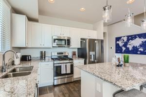 a kitchen with white cabinets and granite counter tops at Brand New Townhome with King Suite Near DIA in Denver
