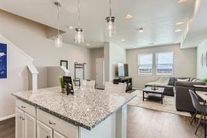 a kitchen and living room with a counter and a living room at Brand New Townhome with King Suite Near DIA in Denver