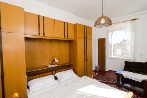 1 dormitorio con 1 cama y armarios de madera en Rooms Pile, en Dubrovnik