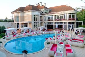 a resort with a swimming pool with red and white chairs at Гостевой Дом у Моря, Guest House by the Sea in Odesa +30 photos