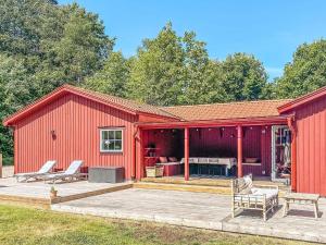 granero rojo con terraza y patio en Holiday home LJUNGBY III, en Ljungby