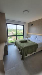 a bedroom with a large bed with a large window at ZUPPOLINI Apart Hotel in Bananeiras