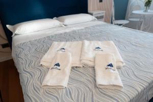 Una cama con toallas blancas y calcetines. en suite la corte en Sannicandro di Bari