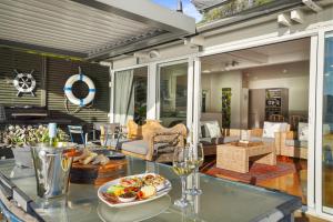 uma sala de estar com uma mesa de vidro com comida em Kaioruru View - Diamond Harbour Holiday Home em Diamond Harbour