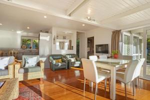 uma sala de estar com mesa e cadeiras em Kaioruru View - Diamond Harbour Holiday Home em Diamond Harbour