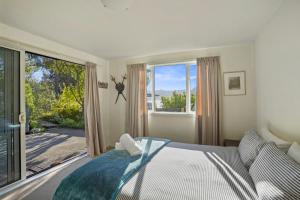 um quarto com uma cama e uma grande janela em Kaioruru View - Diamond Harbour Holiday Home em Diamond Harbour