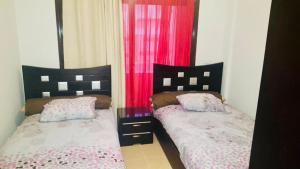 two beds sitting next to each other in a bedroom at Apartment in Blue bay Asian Marsailla Families only chalet pool view قرية بلو باى اسيا مرسيليا العين السخنة in Ain Sokhna
