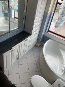 a bathroom with a toilet and a sink and a window at Quite Broad Rest 3 in Longford