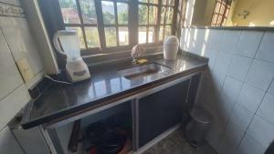 a kitchen counter with a sink and a window at Condomínio Fazenda Garatucaia in Angra dos Reis +6 photos