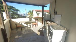 a kitchen with a table and chairs on a balcony at Condomínio Fazenda Garatucaia in Angra dos Reis