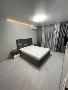 a bedroom with a large bed and a window at VIP new apartment Odessa in Odesa