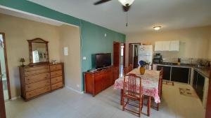 a kitchen with a table with chairs and a television at Descanso e churrasco a beira do mar in Paraty +51 photos