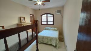 a room with a staircase with a bed and a window at Descanso e churrasco a beira do mar in Paraty