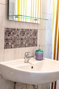 a white sink in a bathroom with a mirror at Ritsinia Apartments in Aigio