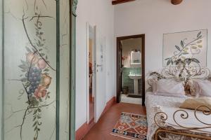 a bedroom with a bed and a wall with a painting at B&B Le Torri Di Firenze in Fiesole