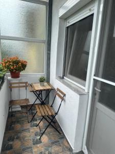 a balcony with two chairs and a table next to a window at Apartments Frau Trena in Gevgelija