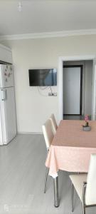 La cuisine est équipée d'une table, de chaises et d'un réfrigérateur. dans l'établissement Güzel evim, à Cayeli