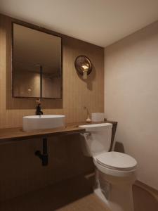 a bathroom with a white toilet and a sink at AWOL Stowe in Stowe