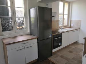 eine Küche mit einem Kühlschrank aus Edelstahl und einer Spüle in der Unterkunft Grand 2P Terrasse bord de seine in Mantes-la-Jolie