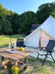 a picnic table with two chairs and a tent at Glamping 4 Acres in Fryšták