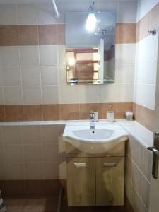 a bathroom with a sink and a mirror and a tub at ΑΝΑΒΑΤΟΣ ΕΞΟΧΙΚΗ ΚΑΤΟΙΚΙΑ in Chios