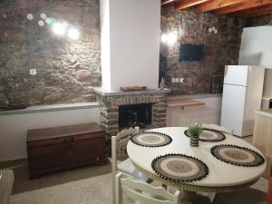 a dining room with a table and a fireplace at ΑΝΑΒΑΤΟΣ ΕΞΟΧΙΚΗ ΚΑΤΟΙΚΙΑ in Chios +29 photos
