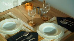 a table with two plates and two wine glasses at Yas Escape - Stylish Boho Studio with Pool, Near Yas Mall in Abu Dhabi +43 photos