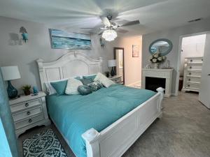 a bedroom with a white bed with a blue comforter at TPC Sawgrass Coastal Retreat in Ponte Vedra Beach