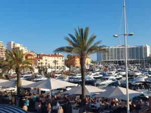 un grupo de personas sentadas bajo sombrillas en un puerto deportivo en Impervila 201 en Vilamoura