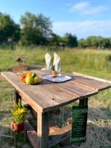 a wooden picnic table with a plate of fruit on it at Glamping 4 Acres in Fryšták