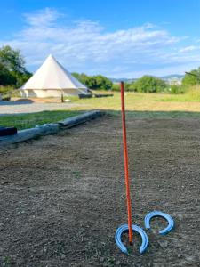 een rode en blauwe paal in het zand met een tent bij Glamping 4 Acres in Fryšták