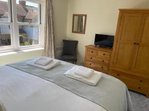 a bedroom with a bed and a tv and a window at Courtyard House, with parking and patio garden in Whitstable