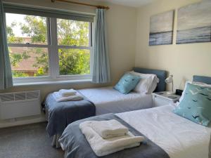 1 dormitorio con 2 camas y ventana en Courtyard House, with parking and patio garden en Whitstable