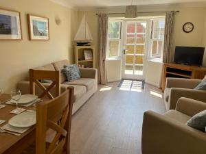 a living room with a couch and a table at Courtyard House, with parking and patio garden in Whitstable