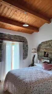 Casa Vacanza Contado Latino في Belmonte del Sannio: غرفة نوم بسرير كبير ونافذة