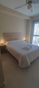 duże białe łóżko w pokoju z oknem w obiekcie luxury homes penthouse con jacuzzi vera, garrucha,mojacar w mieście Vera