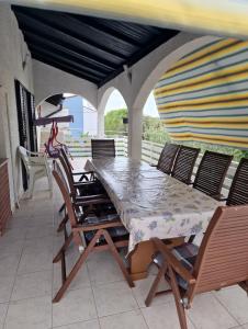 a table and chairs on a patio with a surfboard at Apartments Vesna in Pinezici